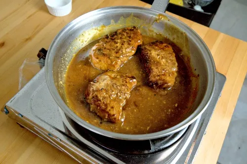 Return the pork chop to the pan.