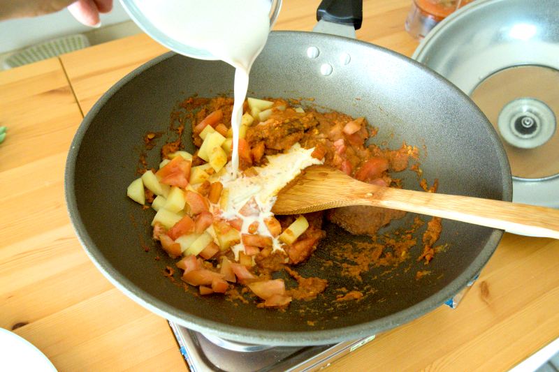 Add the freshly pressed coconut milk to the curry.