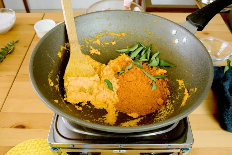 Add the curry leaves and curry powder.