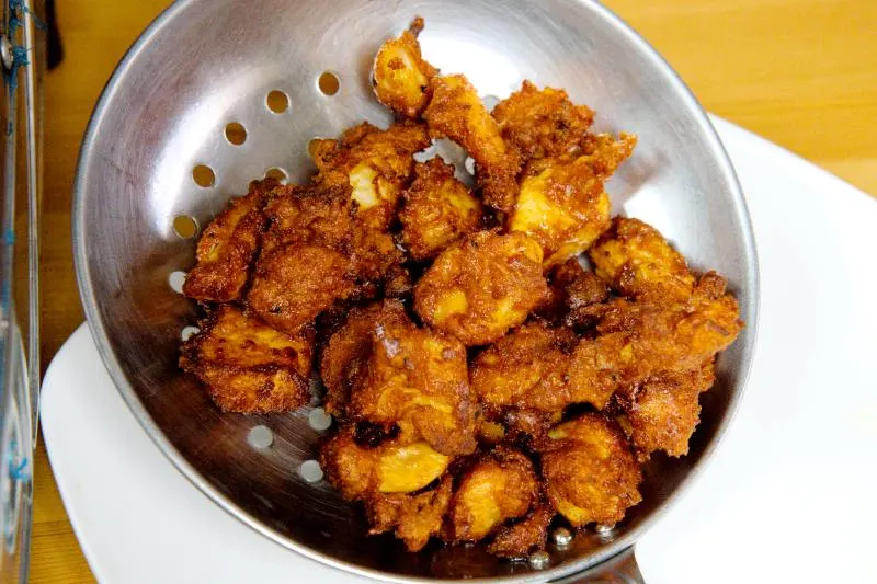 Remove the chicken from the oil with a slotted spoon.