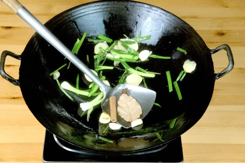 Add the dry spices (bay leaf, cinnamon stick, and star anise) and stir them quickly.  