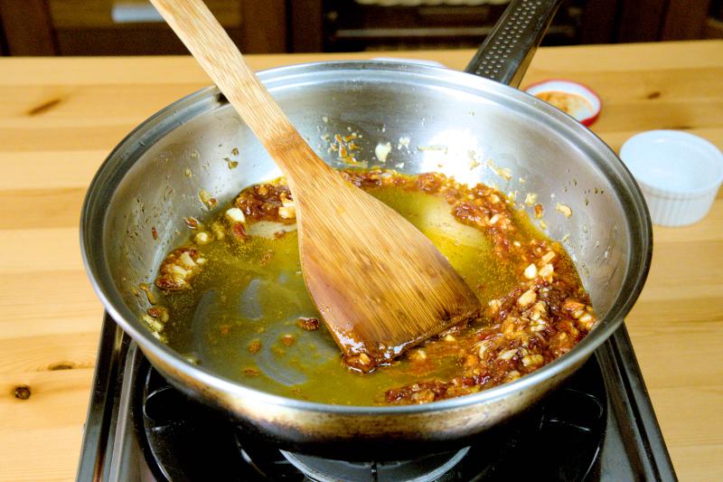 sauté the garlic, ginger, doubanjiang, and dried chili peppers until fragrant.