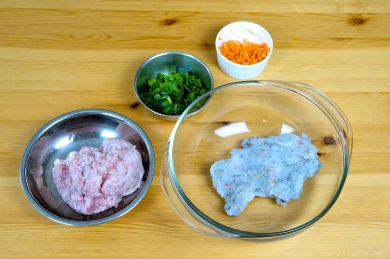 Mix the shrimp paste and cubes with chopped green onion, diced carrot, and minced pork or fish paste.