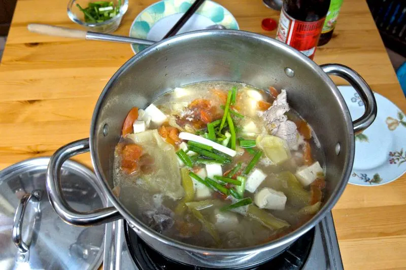 Gently place the tofu cubes into the salted vegetable soup