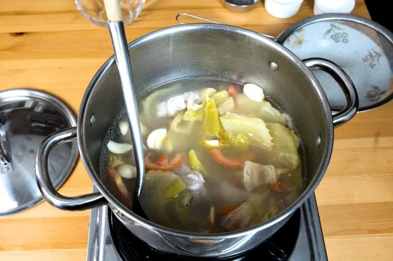 add the salted vegetables, tomatoes, ginger, and garlic into the pot.
