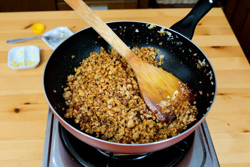 season the pork with chili bean paste and other ingredients
